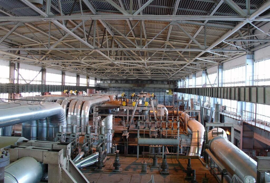 Industrial warehouse interior with large pipes and machinery